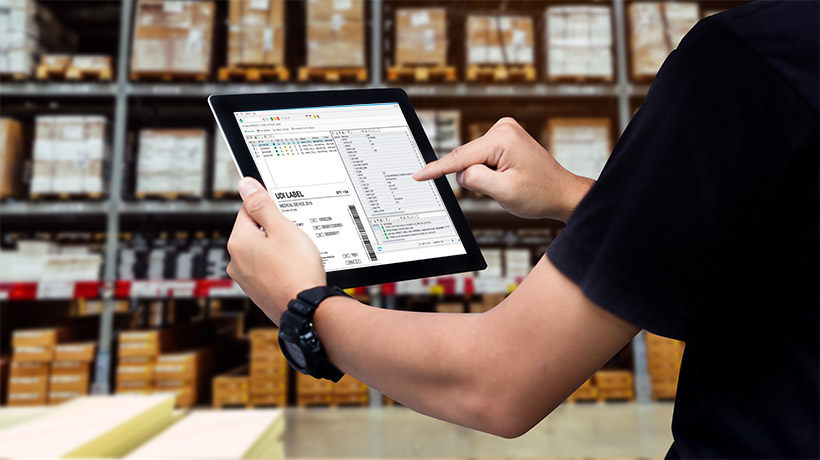 Labeldruck aus SAP EWM EIn Mann mit einem Tablet für Labeldruck aus SAP EWM in einem Lager